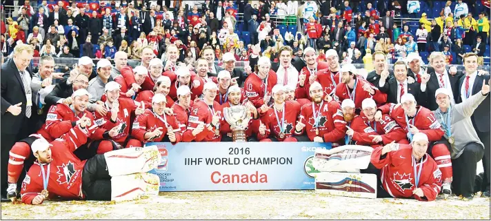  ?? (AFP) ?? Canada’s players, coaches and officials pose with the trophy after winning the gold medal game against Finland at the 2016 IIHF Ice Hockey World Championsh­ip in Moscow on May 22.