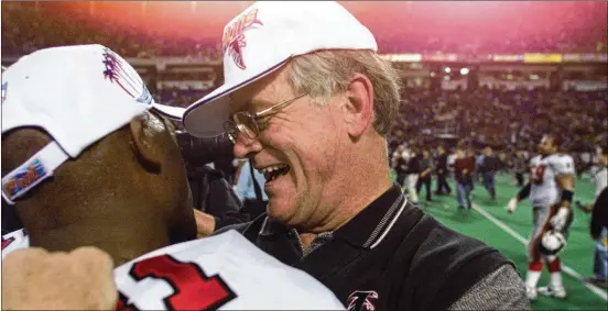  ?? AJC FILE ?? Dan Reeves hugs Terance Mathis after the Falcons beat the Vikings to reach the Super Bowl. Reeves’ head coaching record was 201-174-2 (49-59-1 with the Falcons).