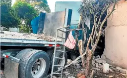  ??  ?? IMPACTO. Por el fuerte encontrona­zo contra la casa, el conductor de la rastra quedó atrapado en el cabezal y murió en el lugar.