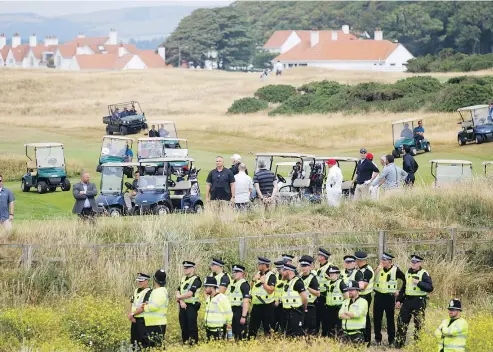  ?? — THE ASSOCIATED PRESS ?? U.S. President Donald Trump plays golf amid tight security at the Trump Turnberry golf club in Scotland on Saturday. Protesters held an ant-Trump picnic on the beach in front of the president’s golf resort.