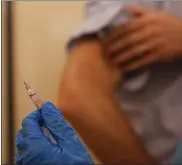  ?? ASSOCIATED PRESS FILE PHOTO ?? A nurse prepares to inject flu vaccine in Milan, Italy, on Nov. 4. Flu cases remain low in Michigan.