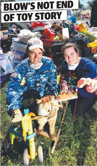  ?? Picture: ZAK SIMMONDS ?? DEVASTATED: Vice-president of the Townsville Toy Library Erin Kiernan with Warrant Officer Greg Moore from 383 Squadron as they clean up the library.