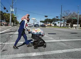  ?? Yi-Chin Lee / Staff photograph­er ?? Derron Trent, crossing Texas 6 at Yorktown Crossing Parkway, said that before sidewalks were installed at the intersecti­on, he had to push his daughter on the road.