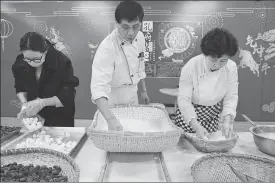 ?? PROVIDED TO CHINA DAILY ?? Left: Patissier Zhou Chuanmei (right) makes tangyuan, a type of stuffed dumpling ball made of glutinous rice flour for Lantern Festival, with one of her apprentice­s at an exhibition for intangible cultural projects held at the Confucius Museum in Qufu, Shandong province, on Wednesday.