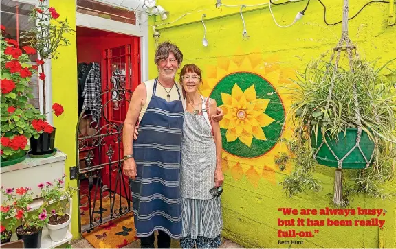  ?? LISA BURD/STUFF ?? Jarrah Edge and Beth Hunt in the brightly painted courtyard garden of their Sugar Juice Cafe.