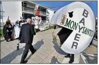  ?? AP/MARTIN MEISSNER ?? Activists protest Friday outside Bayer AG headquarte­rs in Bonn, Germany, against Bayer’s planned $66 billion takeover of Monsanto Co. The companies reached a settlement Tuesday with the Justice Department that clears the last major hurdle to the agreement.