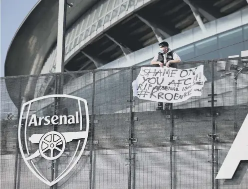  ??  ?? 0 An Arsenal fan stands with his anti-european Super League banner outside the Emirates Stadium, home of Arsenal, in north London