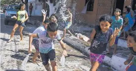  ??  ?? Un grupo de niños juega tirándose bolsas llenas de agua, en el barrio San Felipe.