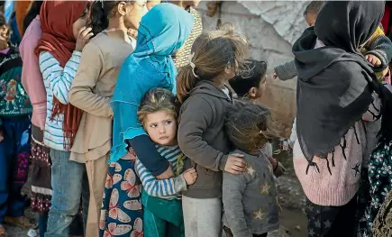  ?? GETTY IMAGES ?? Displaced Syrian children wait in a queue to receive humanitari­an aid supplied by Humanitari­an Relief Foundation’s (IHH) on Thursday in Idlib.