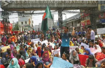  ??  ?? Students shout slogans as they block a road to demand road safety after a student died in a road accident in Dhaka. — Reuters photo