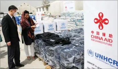  ?? SAIFURAHMA­N SAFI / XINHUA ?? Chinese Ambassador to Afghanista­n Wang Yu (left) attends on March 27 the handover in the capital, Kabul, of humanitari­an supplies donated by a fund.