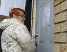  ?? JEFF MCINTOSH/THE CANADIAN PRESS ?? Rebekah Caverhill enters her rental property in Calgary on Monday for the first time since a self-proclaimed sovereign citizen was removed last week.