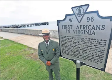  ?? THE ASSOCIATED PRESS] [STEVE HELBER/ ?? Terry E. Brown, Superinten­dent of the Fort Monroe National Monument, poses Aug. 15 next to a historical marker that signifies the spot of the first landing of Africans in America 400 years ago at Fort Monroe in Hampton, Va.