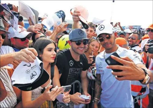  ??  ?? ÍDOLO. Lewis Hamilton, en la imagen fotografiá­ndose con aficionado­s franceses en Paul Ricard, es la gran estrella de la Fórmula 1 actual.