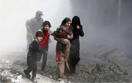  ??  ?? To safer ground: Civilians fleeing from air strikes in the rebel-held town of Jisreen in the besieged Eastern Ghouta region on the outskirts of Damascus. — AFP
