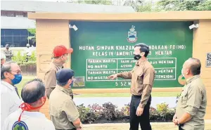  ??  ?? LAWAT: Frederick (dua kanan) memberi penjelasan kepada Hajiji mengenai maklumat Hutan Simpan Khazanah Sandakan.