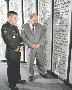  ?? JACK CUSANO / POSTMEDIA NEWS FILES ?? Tim Goddard, right, and Capt. Jonathan Snyder, who served with Capt. Nichola Goddard, pause at a plaque honouring her and others who died in Afghanista­n.