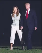  ?? Associated Press photo ?? President Donald Trump and first lady Melania Trump walk from Marine One across the South Lawn to White House in Washington, Saturday as they return from Sigonella, Italy.