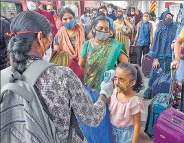  ??  ?? A health worker does thermal screening and checks oxygen levels of passengers for COVID-19 test at Dadar railway station in Mumbai on Saturday.