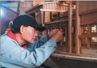  ??  ?? Left: Han Minghua checks a red boat model at his studio in Jiaxing, Zhejiang province.