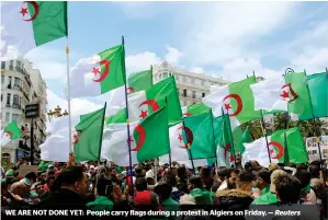  ?? Reuters ?? WE ARE NOT DONE YET: People carry flags during a protest in Algiers on Friday. —