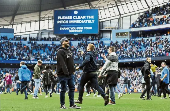  ?? — AP ?? Not cool: Manchester City fans invading the pitch after the English Premier League match against Swansea at the Etihad on Sunday.