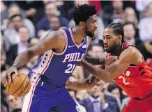  ?? THE CANADIAN PRESS/FRANK GUNN ?? The Raptors’ Kawhi Leonard defends the 76ers’ Joel Embiid, who struggled in his team’s loss on Wednesday.