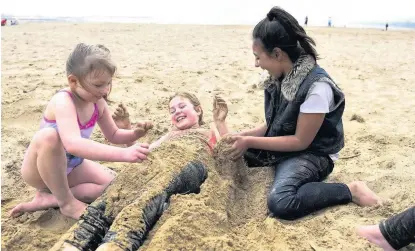  ?? ROBERT MELEN ?? The spring sunshine found the Welsh seaside yesterday as warmer weather made a welcome return. Pictured playing in the sand in Swansea Bay are friends Alaia Morgan, six, Ella Bradford, nine, and Imahni Shafy, 10