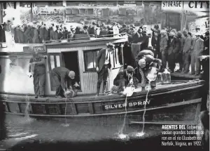  ??  ?? Agentes del Gobierno vacían grandes botellas de ron en el río Elizabeth en Norfolk, Virgina, en 1922.