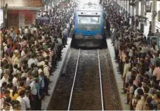  ?? — AFP ?? Commuters board a train at a railway station in Colombo.