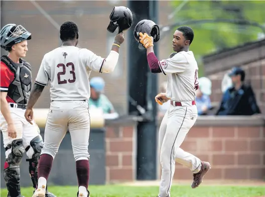  ?? VINCENT D. JOHNSON/DAILY SOUTHTOWN ?? Brother Rice’s Bryce Nevils, right, taps helmets with Amir Gray after a home run against Marist during Sunday’s game in Chicago.