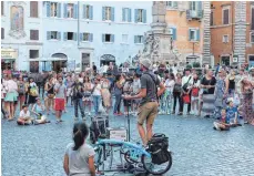  ??  ?? Am Abend atmet Rom durch: Besucher auf der Piazza Rotonda hören einem Straßenmus­iker zu.