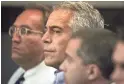  ??  ?? Two law enforcemen­t officials say Jeffrey Epstein, center, was taken into federal custody Saturday on charges involving sex-traffickin­g allegation­s.