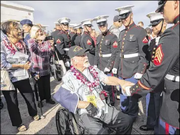  ?? EUGENE TANNER / AP ?? Pearl Harbor veteran Donald Barnhart (center) shakes the hand of a Marine during the 75th Anniversar­y National Pearl Harbor Remembranc­e Day Commemorat­ion at Kilo Pier, Joint Base Pearl Harbor-Hickam, on Wednesday in Honolulu.