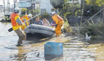  ?? Picture: AFP ?? HIGH GROUND. Fire department workers evacuate residents from a flooded area in Date, Fukushima, one day after typhoon Hagibis swept through central and eastern Japan. At least 20 people are dead and 15 others are missing, officials said.