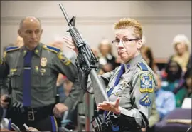  ?? Jessica Hill Associated Press ?? A STATE police detective displays a Bushmaster XM-15, the same model used by Lanza in the massacre, during a 2013 legislativ­e hearing in Hartford, Conn.