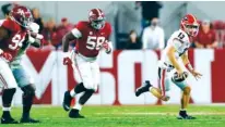  ?? PHOTO BY SKYLAR LIEN ?? Georgia quarterbac­k Stetson Bennett scrambles away from Alabama defenders DJ Dale (94) and Christian Barmore (58) during Saturday night’s 41-24 loss to Alabama inside Bryant-Denny Stadium.