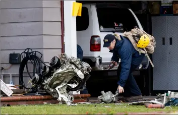  ?? PAUL BERSEBACH/THE ORANGE COUNTY REGISTER VIA AP ?? A National Transporta­tion Safety Board worker takes a photo of an engine that came to rest against a house on Crestknoll Drive. in Yorba Linda, Calif. on Monday.