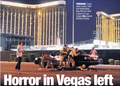  ??  ?? TERROR Cops take cover near the Mandalay Bay Resort and Casino in Las Vegas Pic David Becker/Getty