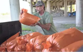  ?? JOE RAEDLE/GETTY IMAGES ?? Ken Allen fills sandbags Aug. 24 in preparatio­n for Hurricane Laura in Morgan City, La. The storm killed at least 40 people.