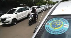  ?? DIPTA WAHYU/JAWA POS ?? BUTUH PEMERINTAH: Taksi online melintas di jalan protokol. Asosiasi driver online memprotes tarif per kilometer yang kerap berubahuba­h.