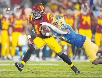  ?? Mark J. Terrill The Associated Press ?? UCLA linebacker Darius Muasau tries to tackle Southern California running back Raleek Brown during the first half of the No. 7 Trojans’ 48-45 win Saturday night.