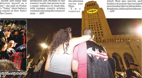  ??  ?? People watch as the Batman ‘Bat-signal’ is projected onto Los Angeles City Hall in a tribute to the late actor Adam West, on Thursday in Los Angeles. — AFP/Reuters photos