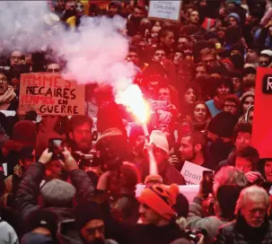  ??  ?? Anger: A flare is lit as placard-waving striking workers take to the streets of Paris yesterday