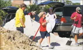  ?? Mic Smith / Associated Press ?? Residents of Isle of Palms, S.C., fill sand bags at the Isle of Palms municipal lot, where the city was giving away free sand in preparatio­n for Hurricane Florence on Monday.