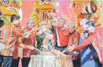  ??  ?? Ahmad Zahid (centre) tossing ‘Yee Sang’ at the opening of the Chinese New Year gathering for Rela Sarawak. Also present were Deputy Chief Minister Tan Sri Dr James Jemut Masing (fourth right) and other honourable guests. — Bernama photo