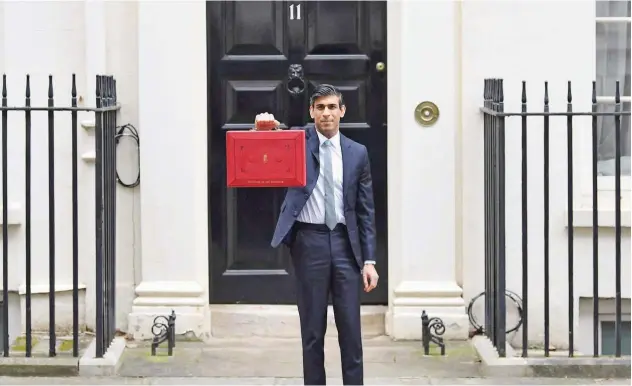  ?? Agence France-presse ?? ↑
Rishi Sunak poses with the Budget Box as he leaves 11 Downing Street before presenting the government’s annual budget to Parliament in London on Wednesday.