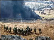  ?? LIOR MIZRAHI/GETTY IMAGES ?? Israeli soldiers take positions as Palestinia­ns gather for a protest on the Israel-Gaza border Friday in Netivot, Israel. Thousands of Gaza residents protested as part of their “March of Return” drive.
