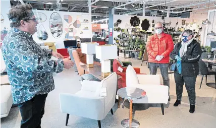  ?? PAUL CHIASSON
THE CANADIAN PRESS ?? A sales clerk keeps his distance from clients at a furniture store in St-Jean-sur-Richelieu, Que., on Monday.