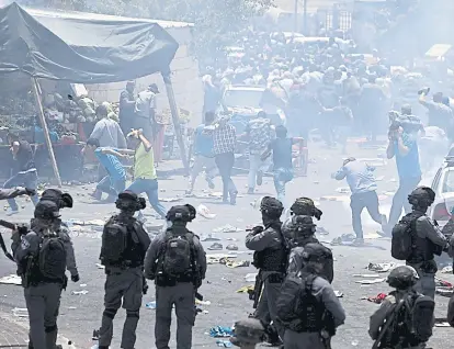  ?? (AP) ?? Corridas. Palestinos escapan de la presión con gas de los soldados israelíes en Jerusalén.